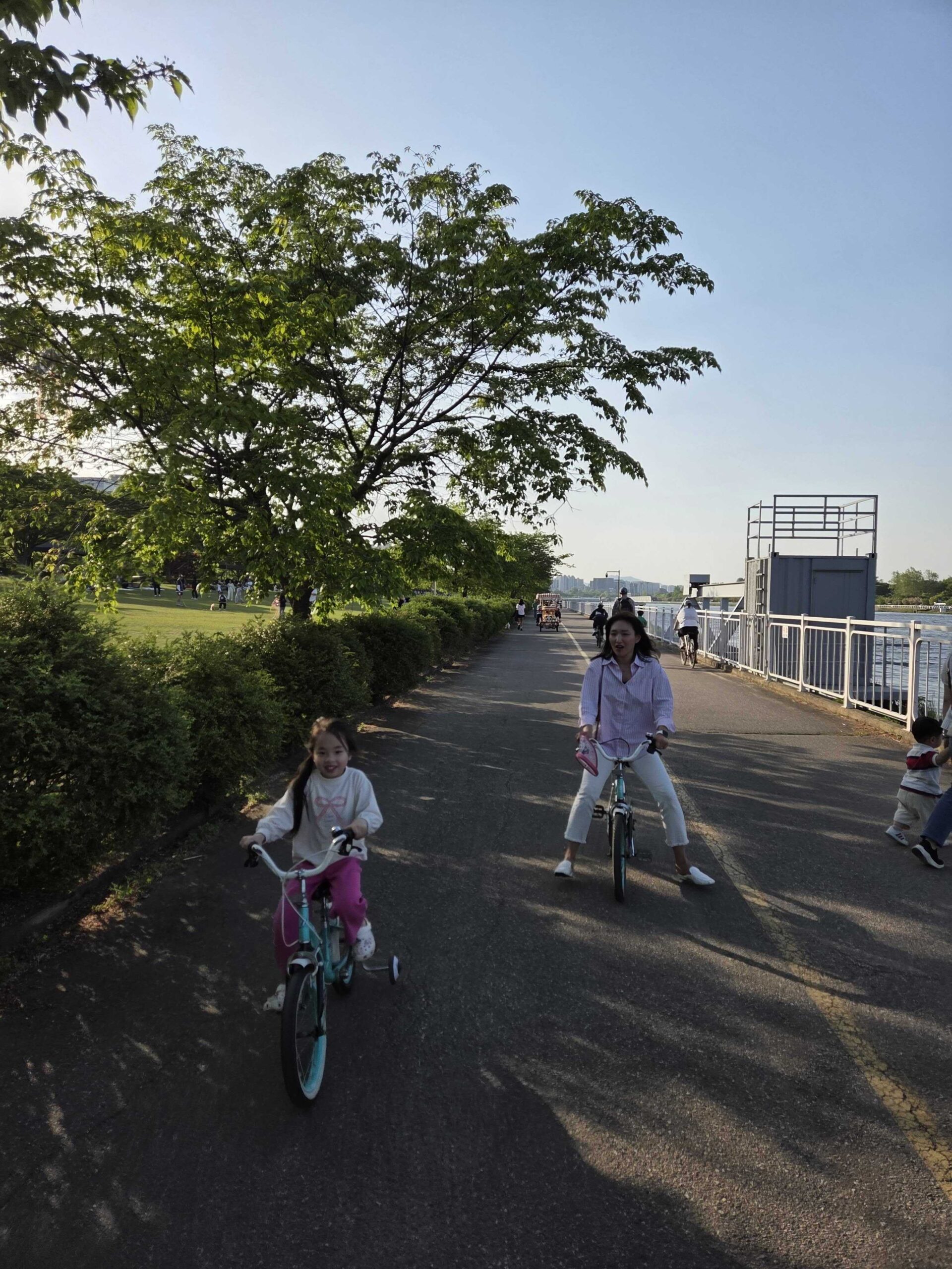 Misari Park Hanam paved river path with a child cycling alongside an adult cyclist