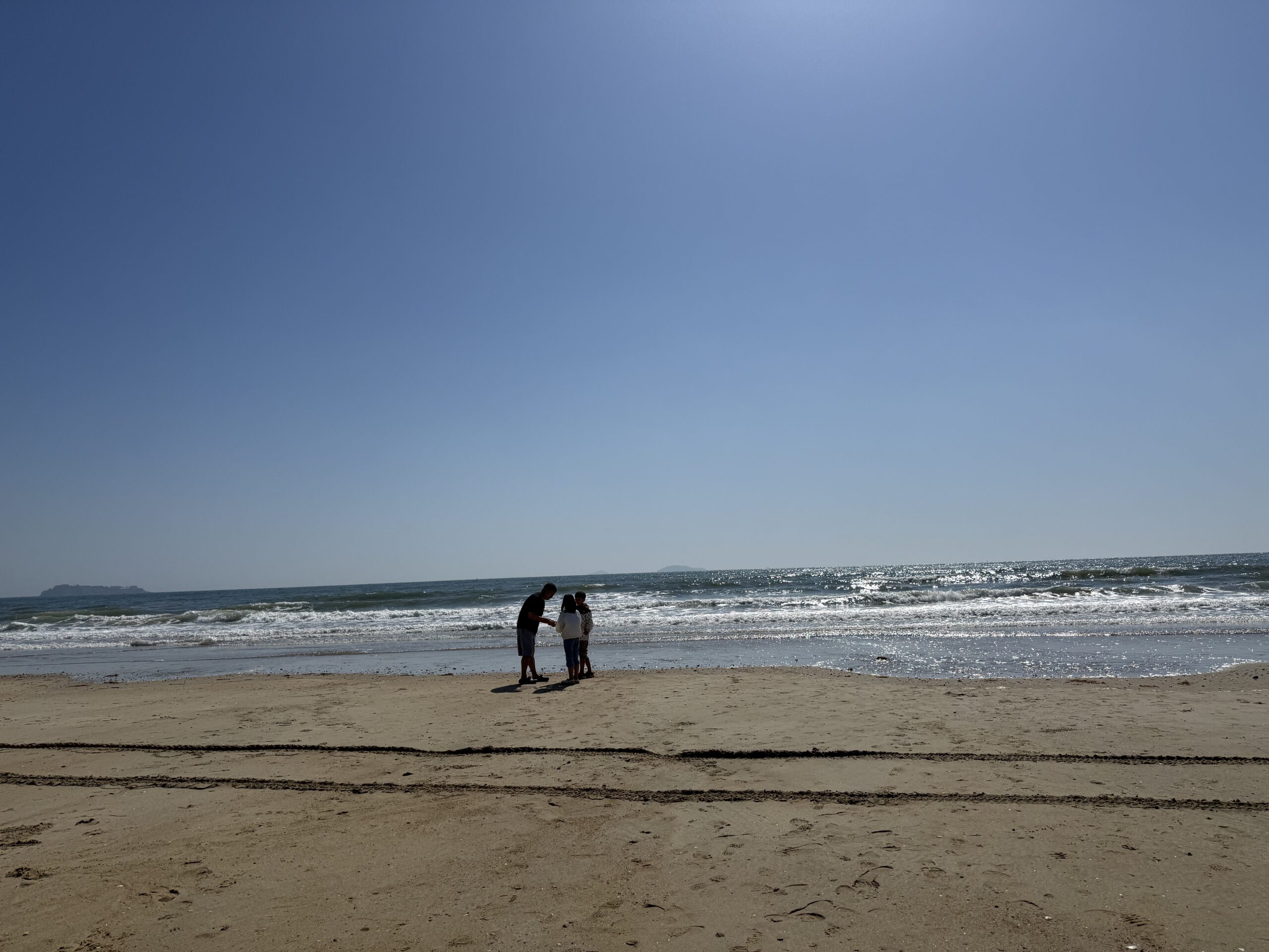 Child examining shells on Kkotji Beach Anmyeondo sand