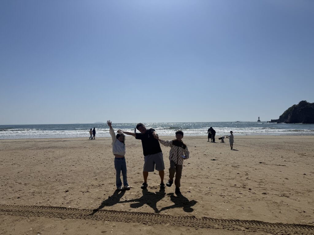 Family silhouette walking on Kkotji Beach in afternoon light