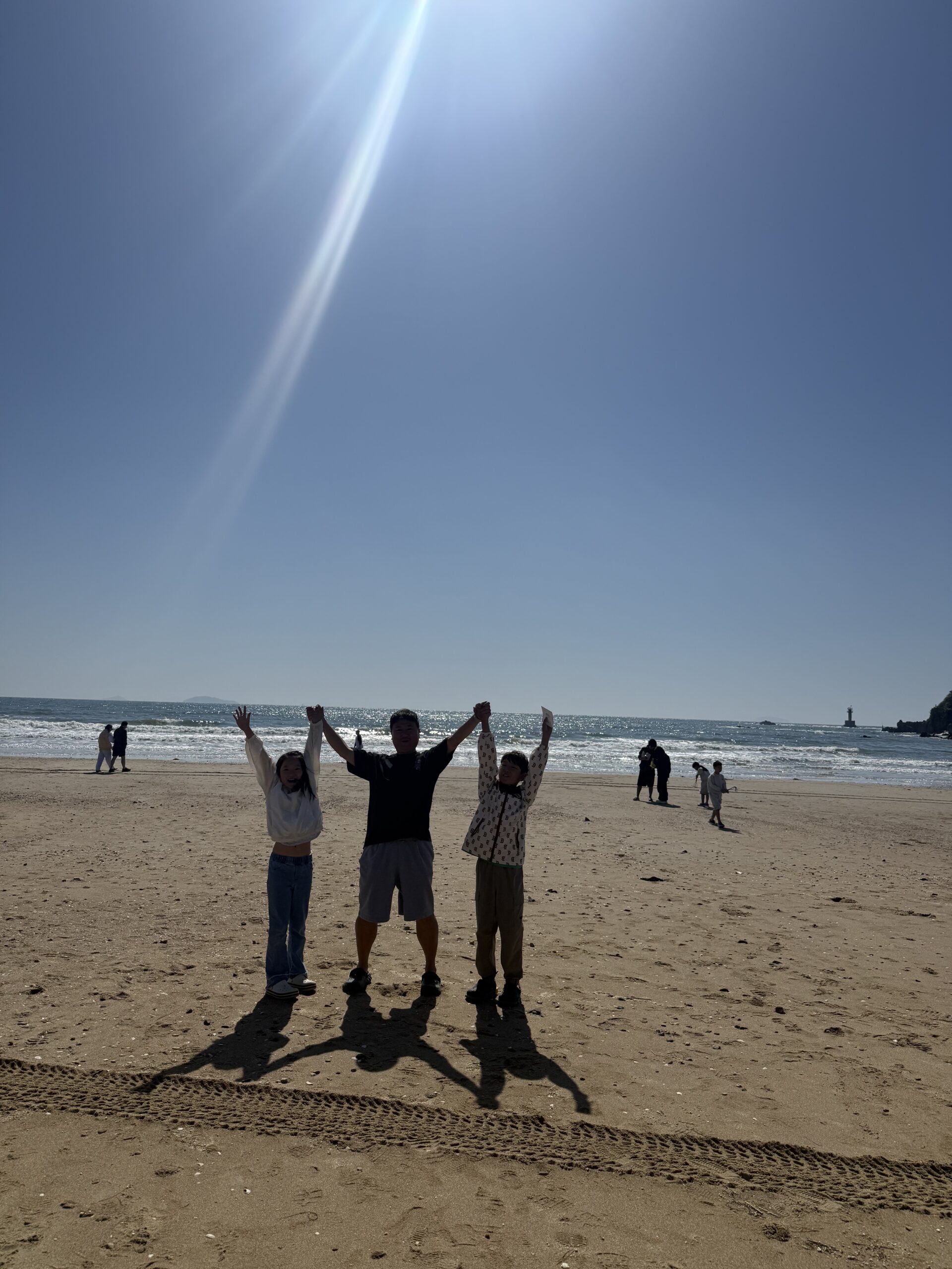 Father and children silhouette on Kkotji Beach with kids late afternoon