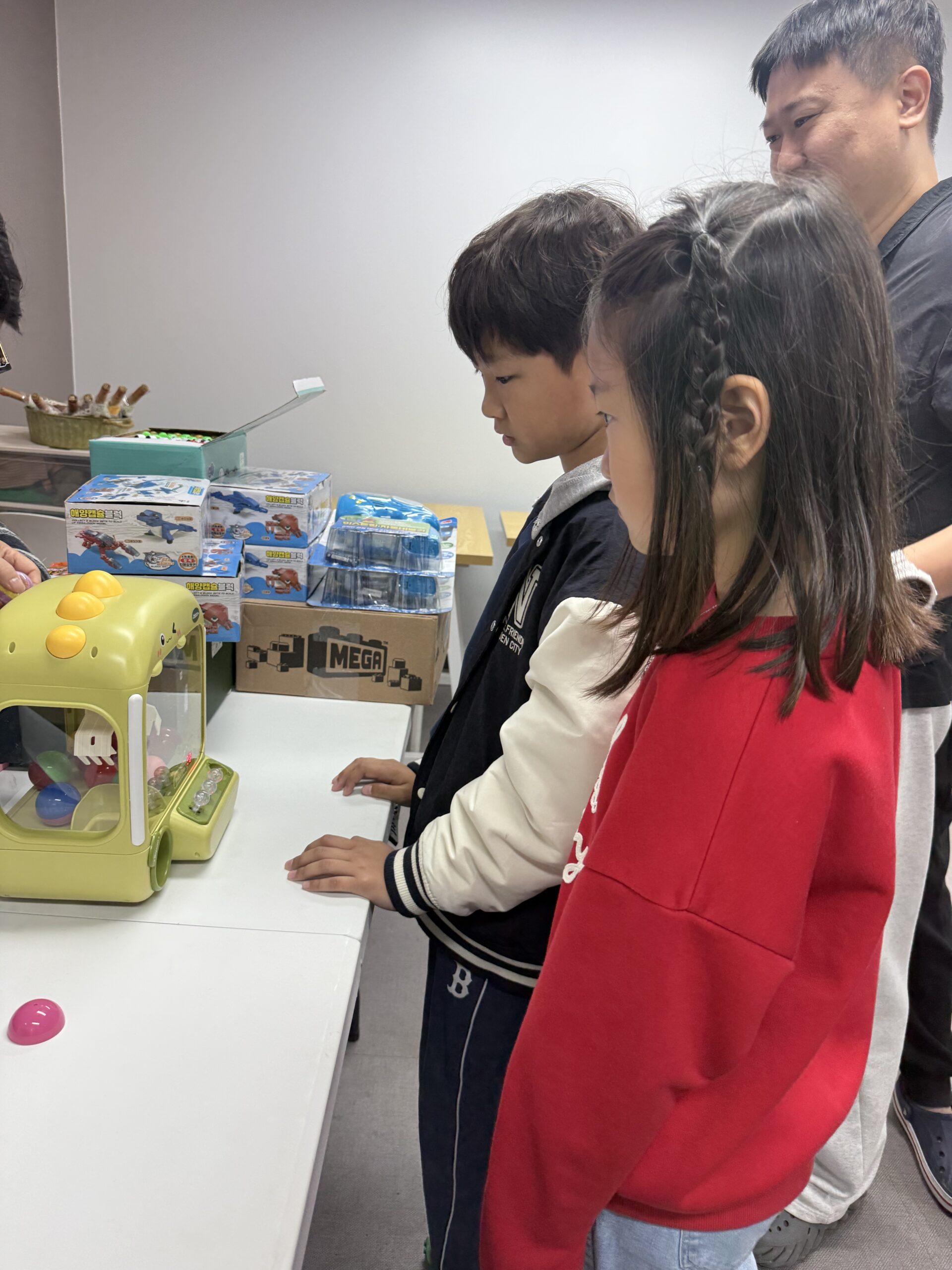 Children at flea market claw machine luck draw game at Naepo Camping Square