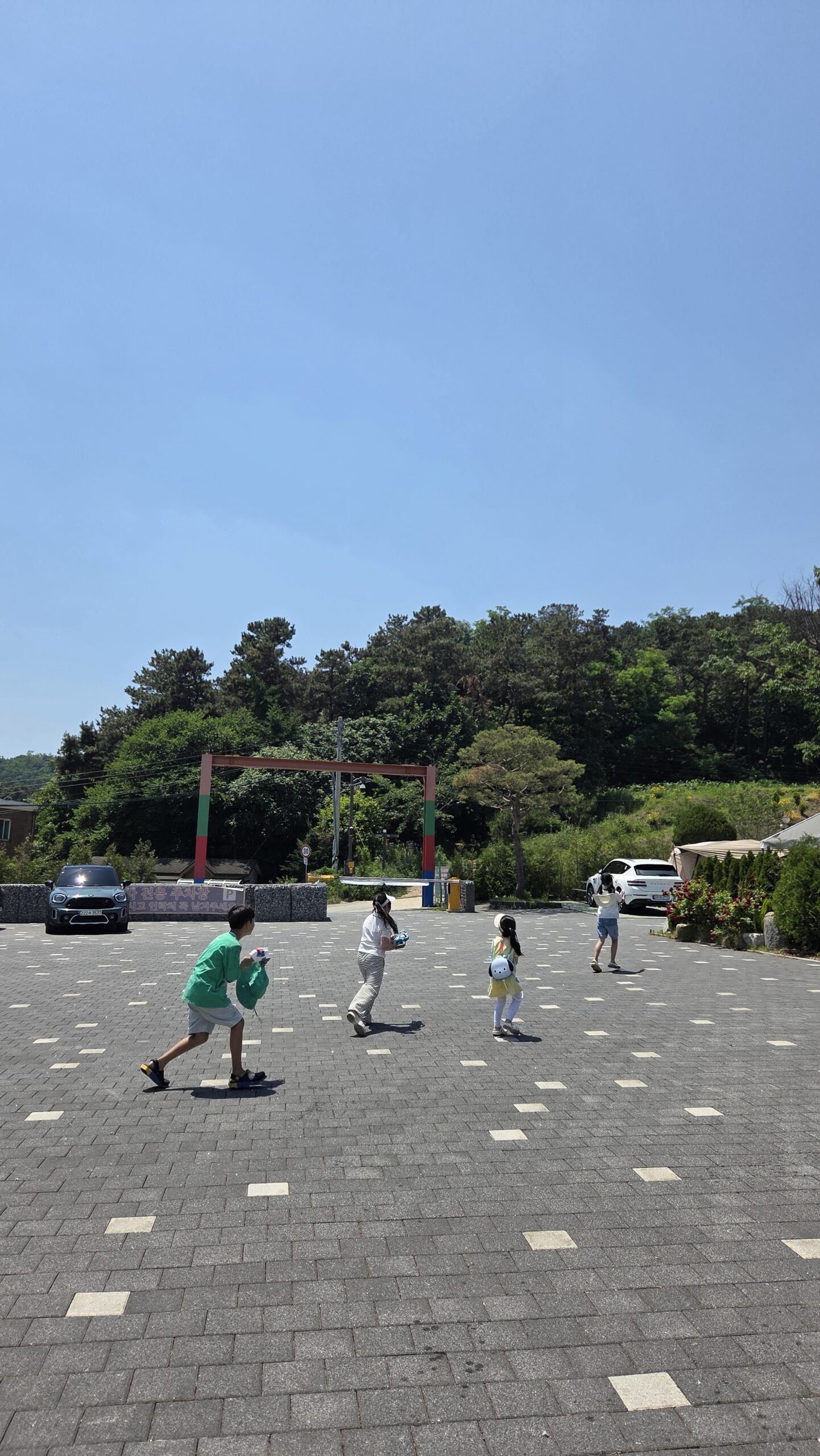Wide camp road with kids running near Choihu Camping Hanam entrance