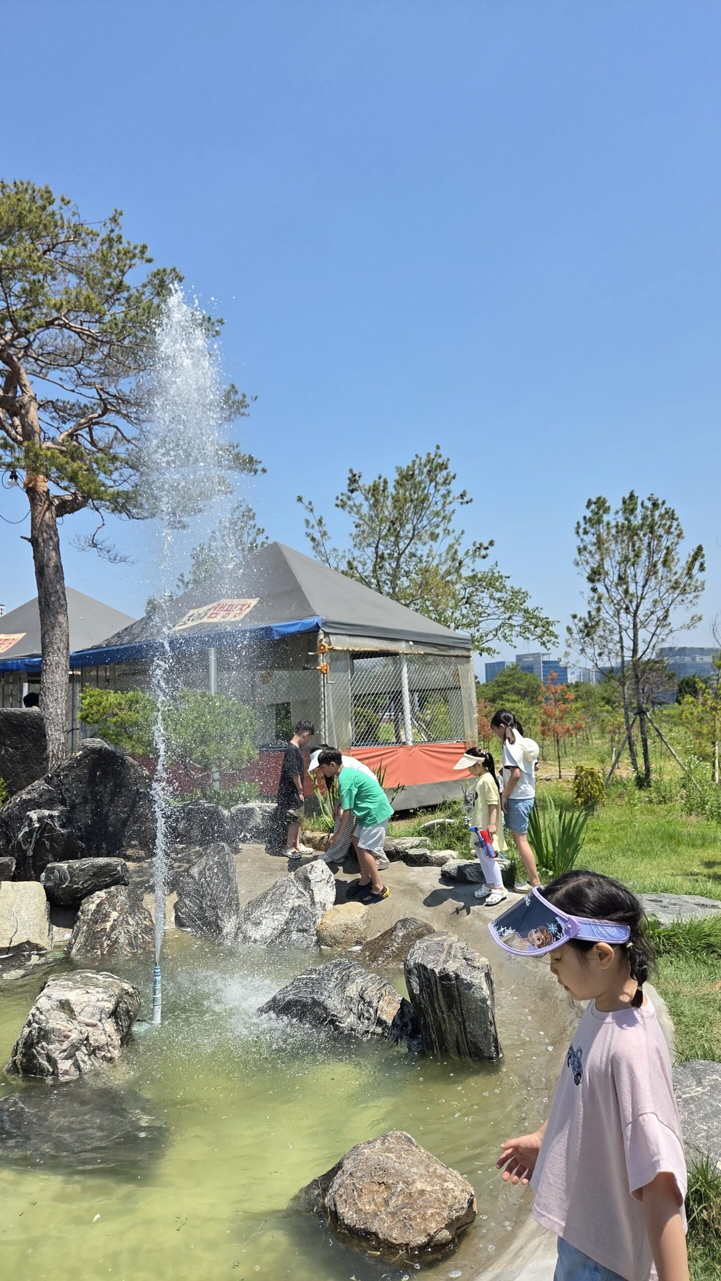 Water plaza with rocks and kids at Choihu Camping Hanam