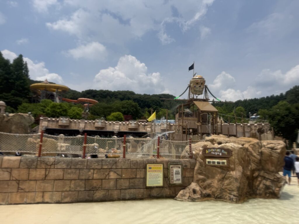 Water slide tower at Caribbean Bay with kids against a cloudy sky