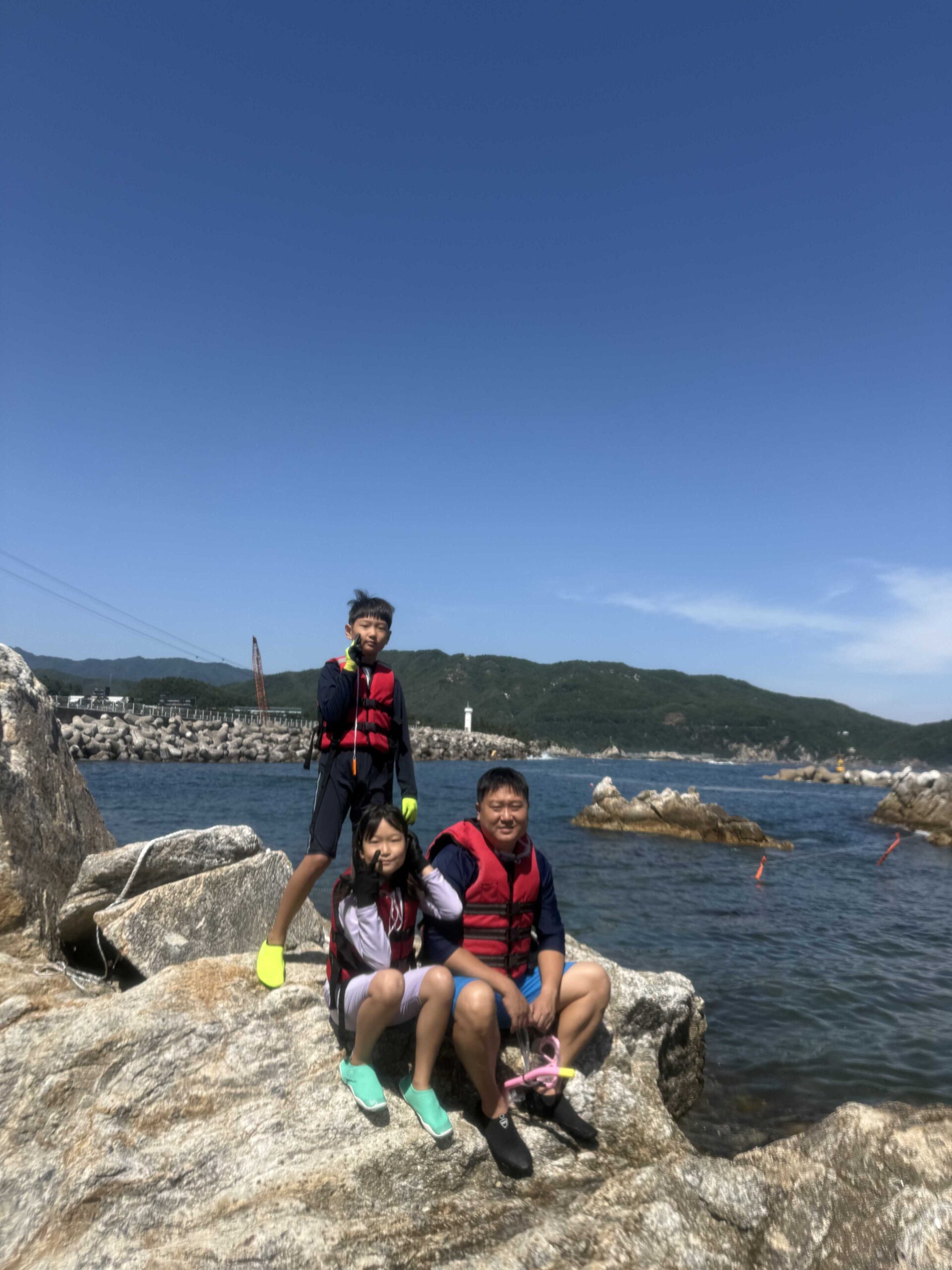 Ticket booth at Jangho Beach with kids showing clear-canoe and snorkeling prices in Samcheok