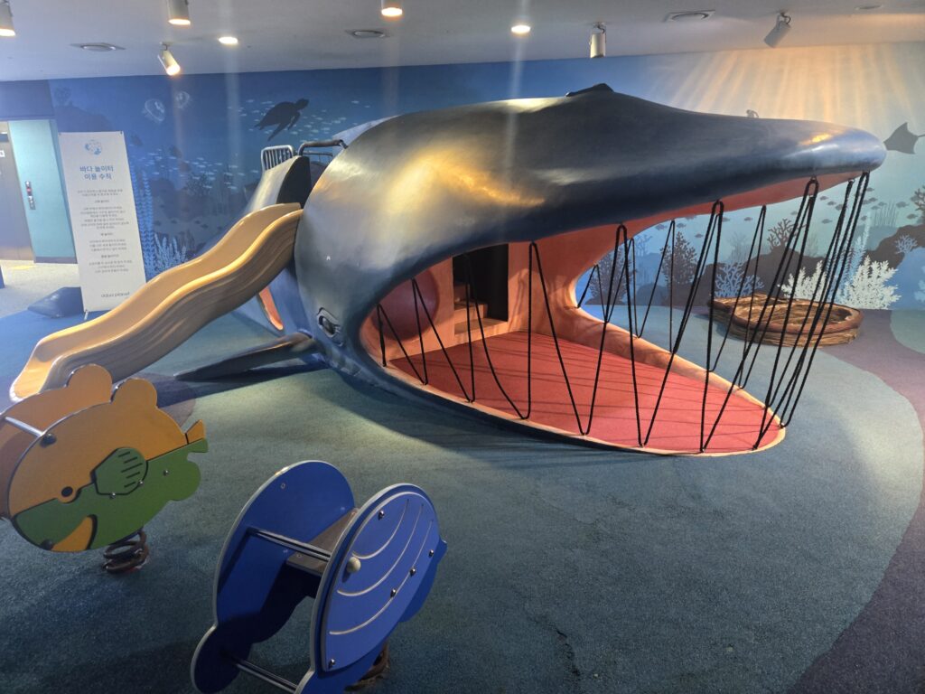 Whale-shaped indoor playground with a slide at Aqua Planet Jeju
