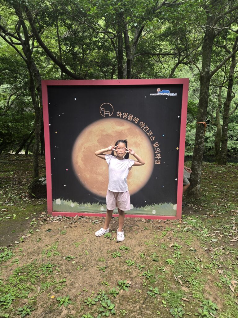 Child at a moon photo zone near Cheonjiyeon Waterfall