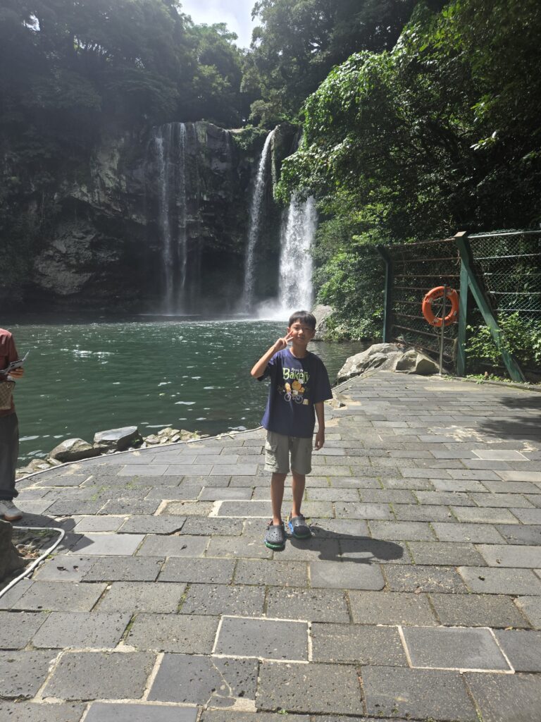 Child on the stone path in front of Cheonjiyeon Waterfall
