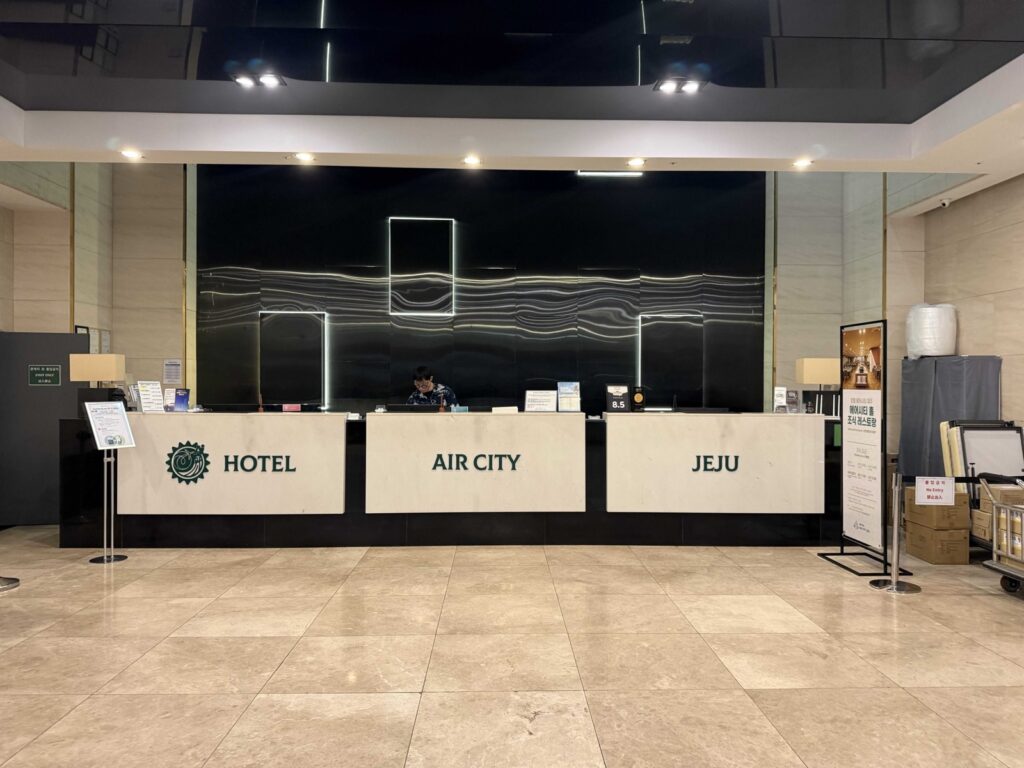 Hotel Aircity Jeju lobby front desk with lit sign
