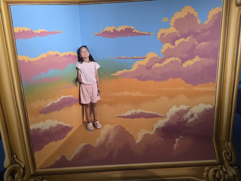Child standing in a cloud picture-frame room at the Jeju trick art museum
