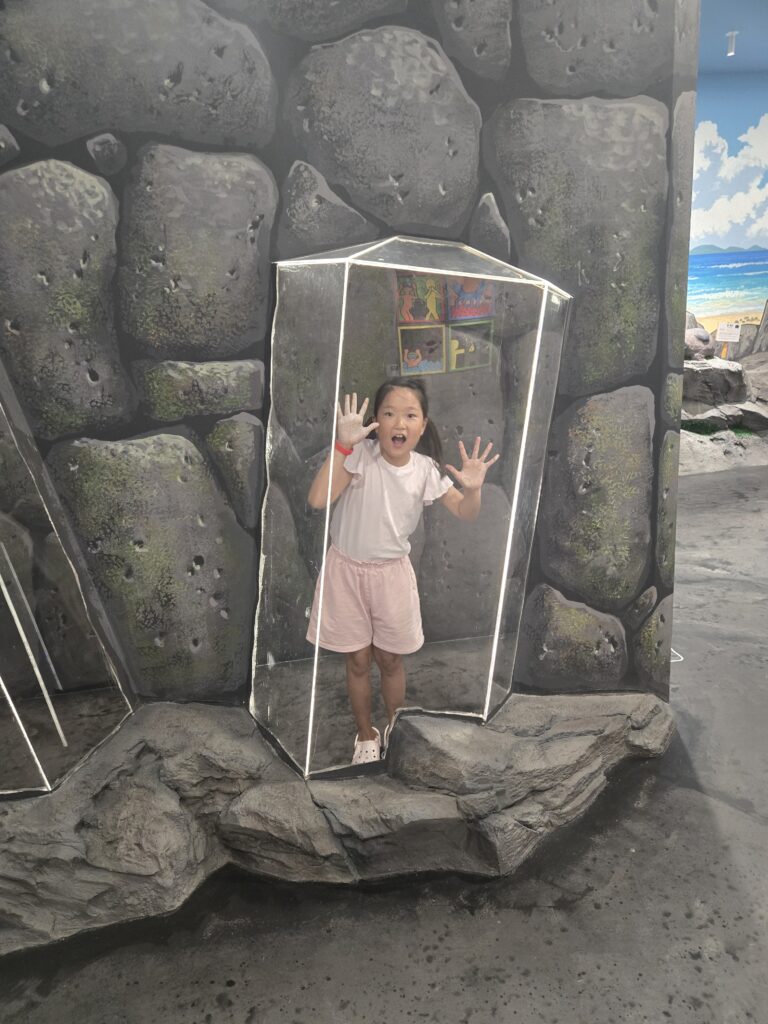 Child inside a 3D glass box illusion on Jeju rock at the trick art museum