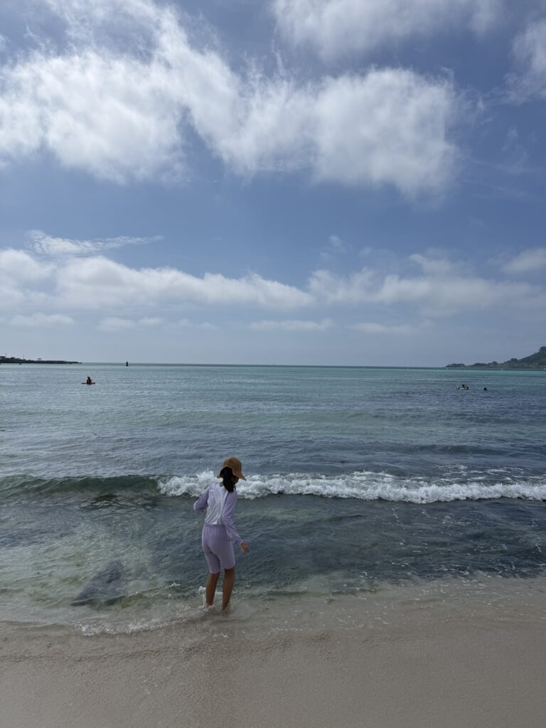 Child wading into the calm shallow water at Segial Beach Jeju