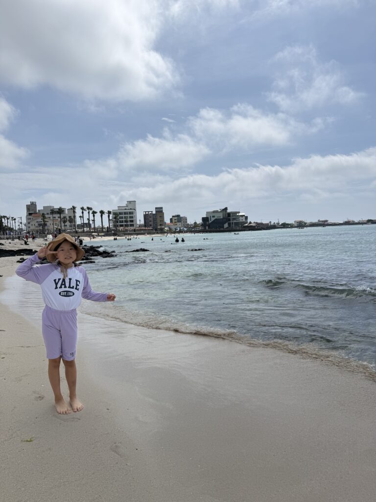 Child standing on the white sand at Segial Beach Jeju