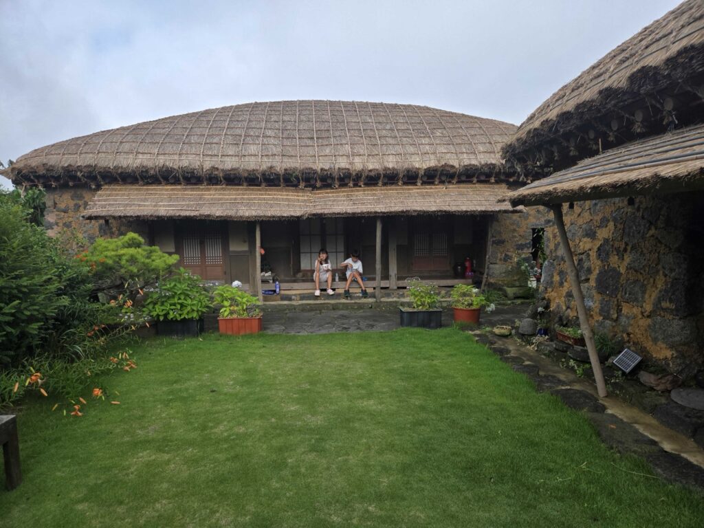 Thatched hanok and green courtyard at our Seongeup Folk Village stay