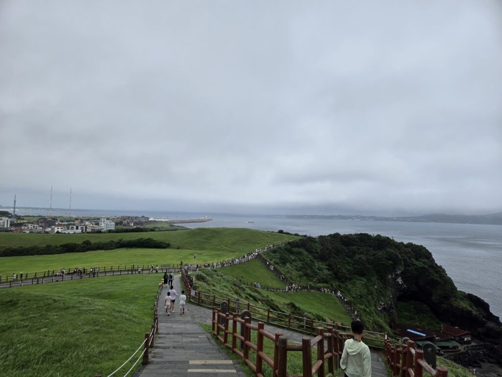 Wide descent path at Seongsan Ilchulbong with kids and the sea beyond