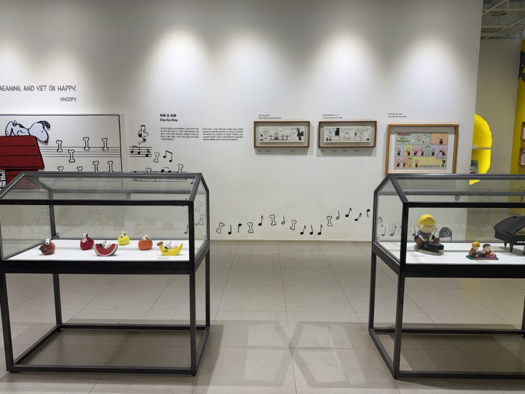 Peanuts comic art and figurine cases inside Snoopy Garden Jeju