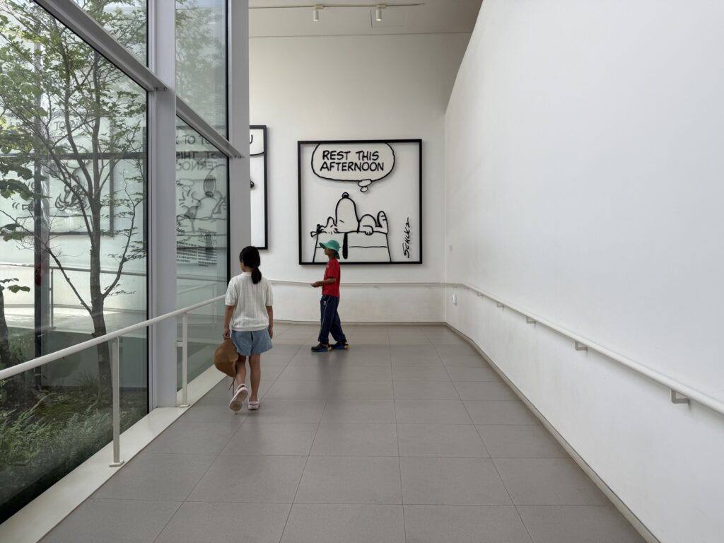 Kids looking at Peanuts artwork in a gallery at Snoopy Garden Jeju