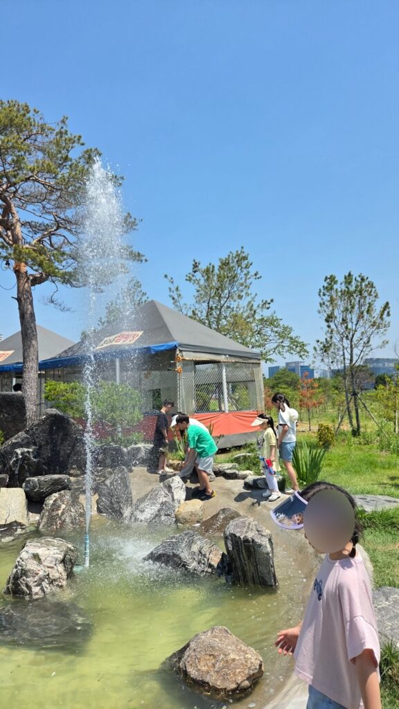 Water plaza with rocks and kids at Choihu Camping Hanam