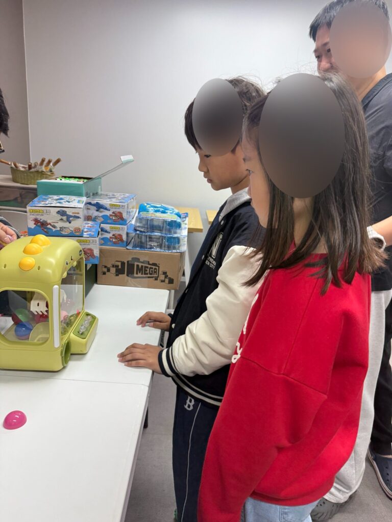Children at flea market claw machine luck draw game at Naepo Camping Square