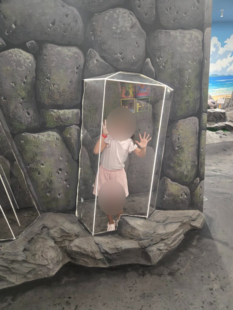 Child inside a 3D glass box illusion on Jeju rock at the trick art museum