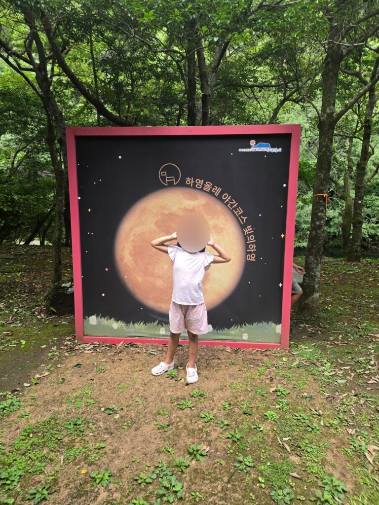 Child at a moon photo zone near Cheonjiyeon Waterfall