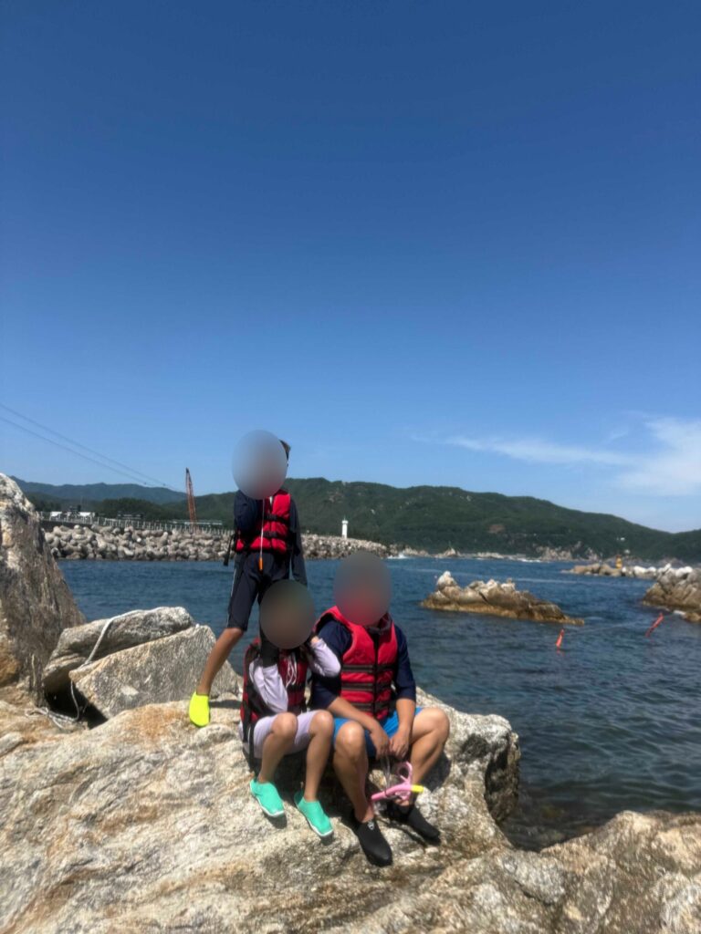 Ticket booth at Jangho Beach with kids showing clear-canoe and snorkeling prices in Samcheok