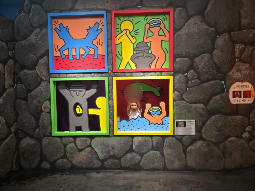 Child in a pop-art frame illusion at the Jeju trick art museum