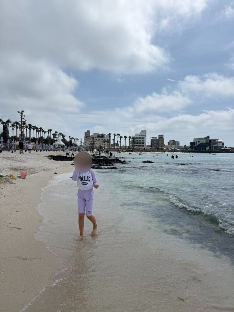 Child at the water's edge at Segial Beach Jeju