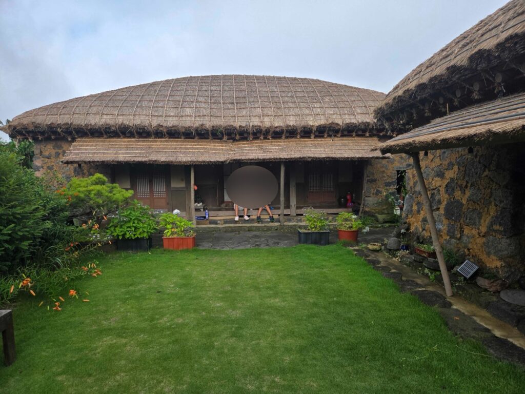 Thatched hanok and green courtyard at our Seongeup Folk Village stay