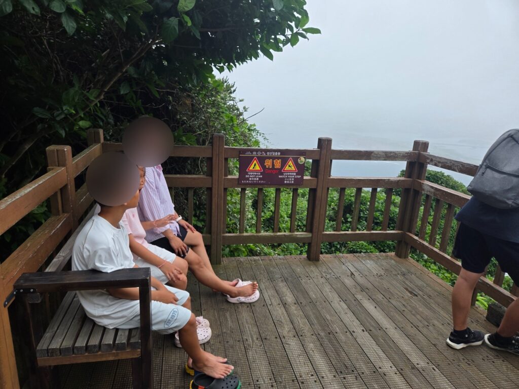 Kids resting on a bench partway up Seongsan Ilchulbong