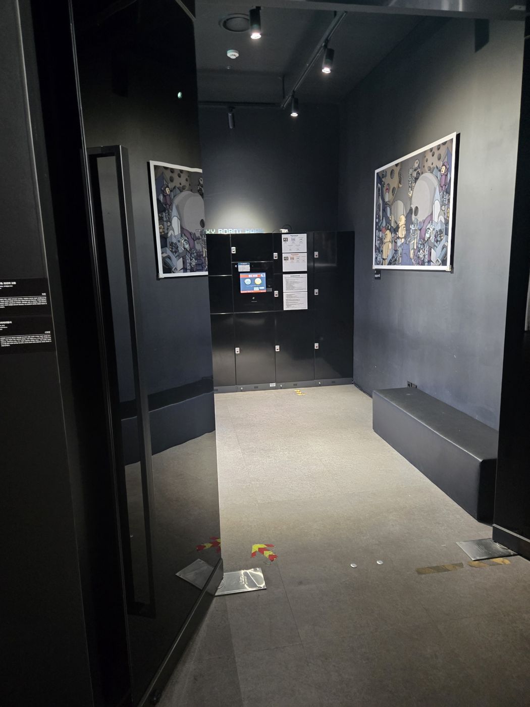 Row of black lockers and a bench in a small room inside Robot Arena