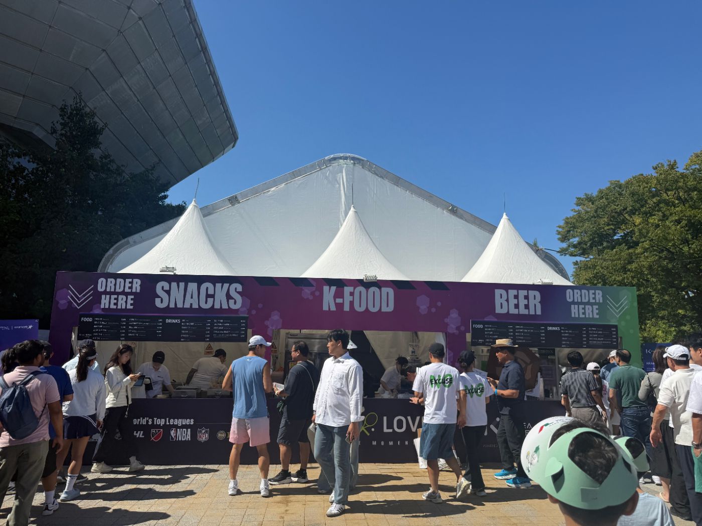 Food stands labeled Snacks, K-Food and Beer under white tents, with menu boards